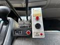 Control panel of a 2009 Ford LCF 550 featuring multiple levers and buttons including a light indicator and body up control with red lights and warning labels