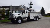 A white 2012 International 7400 utility truck with a mounted crane and equipment compartments on the side