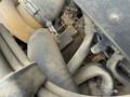 Close-up of a 2011 John Deere 310SJ 4x4 Wheel Loader's engine components including hoses and a turbocharger