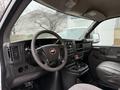 Interior view of a 2009 Chevrolet Express van focusing on the dashboard steering wheel and front seats