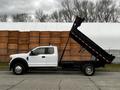 A white 2019 Ford F-550 with a raised dump bed showcasing its large size and robust design