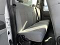Interior of a 2011 Ford F-450 SD showing the gray cloth bench seat in the back with a textured surface and seatbelt attachments