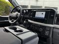 Interior view of a 2024 Ford F-550 showing the steering wheel dashboard touchscreen and control panel with cup holders