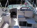 A 1991 Larson Mirado boat interior featuring a steering wheel a captain's chair a table and various controls and storage compartments