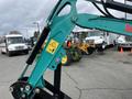 A 2024 AGT Industrial Green QH13R Mini Excavator with a bright green arm and black attachment in the foreground