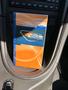 A 2003 Ford Mustang owner's guide with an orange and blue cover resting in the cup holder of the vehicle