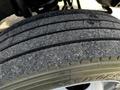 Close-up of a used tire from a 2008 Ford F-550 showing tread pattern and wear with some debris visible in the grooves