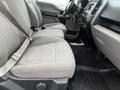 A 2017 Ford F-150 interior featuring grey fabric seats and a dashboard with controls and a console visible in the foreground