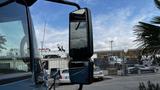 A 2009 International 4300 truck's side mirror reflecting surroundings with a clear view of the reflective surface and integrated design