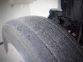 Close-up of a worn tire from a 2012 International DuraStar 4300 showing visible tread wear and small debris on the surface