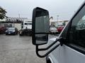 A 2015 Chevrolet Express with a side mirror displaying raindrops on its surface