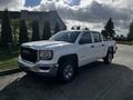 A 2017 GMC Sierra 1500 pickup truck with a white exterior and chrome accents parked on a concrete surface