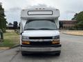 Front view of a white 2020 Chevrolet Express with a windshield and black grill prominently displayed