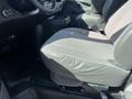 A gray fabric and leather driver's seat of a 2013 Chevrolet Express with a flat surface and armrest visible in the foreground