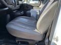 A black leather driver's seat in a 2014 Chevrolet Express van with visible wear and a slight crease in the cushion