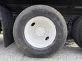 A close-up of a large black tire mounted on a white wheel from a 2016 International 7600 with visible tread and a center hub