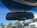 A rearview mirror of a 2011 RAM 1500 showing a blacked-out reflection with a small green indicator light visible