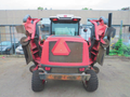 A red 2013 Toro Grounds Master 5910 with two large mowing decks extended on either side and a triangular hazard sign on the rear