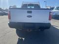 A 2014 Ford F-250 Super Duty truck viewed from the rear with a white exterior and visible tailgate and bumper