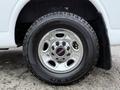 Close-up of a chrome wheel with a GMC center cap and all-terrain tire on a white van