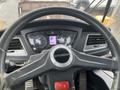 The interior view of a 2016 Hyundai HL940 featuring a steering wheel with the Hyundai logo and a dashboard displaying gauges and a gear indicator