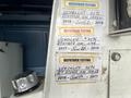 A 2006 Ford Econoline with various inspection and testing stickers affixed to its interior wall