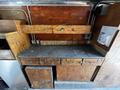 A wooden workbench with multiple drawers and compartments showing signs of wear and use