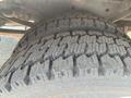 Close-up of a large tire with deep treads mounted on a heavy-duty 2015 Ford F-450 SD vehicle