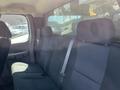 The interior view of a 2013 Chevrolet Silverado 1500 showing the back seat with black fabric upholstery and seatbelts