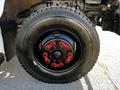 Close-up of a black tire with red wheel nuts on a 2022 Blue Bird Vision showcasing the detailed tread pattern and sturdy construction