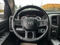 Steering wheel of a 2022 RAM 1500 Classic featuring the RAM logo and buttons for various controls including audio and cruise settings