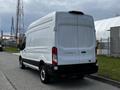 A 2020 Ford Transit van in white with a high roof and rear cargo doors parked on a street