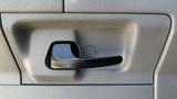 Close-up of a black door handle on a gray panel of a 2013 Ford Econoline