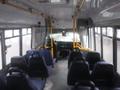 Interior of a 2016 Chevrolet Express with rows of blue seats and a view of the driver's seat and dashboard at the front