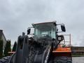 A 2018 Doosan DL300-5 wheel loader with a large bucket and distinctive orange and black color scheme facing forward