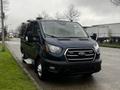 A blue 2020 Ford Transit van with a front grille featuring the Ford logo and prominent headlights is parked on the side of the road