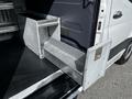 A 2020 Mercedes-Benz Sprinter with metal storage compartments extending from the side door
