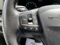 Close-up of a steering wheel control panel featuring buttons for setting cruise control, adjusting speed, and managing audio functions on a 2022 Ford Transit