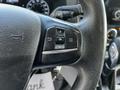 Close-up of the steering wheel controls of a 2021 Ford Transit featuring buttons for navigation and settings