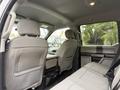 The interior of a 2020 Ford F-550 showing the back seats with gray upholstery and a center console