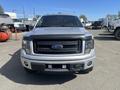 A 2014 Ford F-150 truck in silver with a black front grille and headlights visible