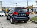 A blue 2013 Dodge Journey SUV parked with a visible rear view showcasing its sporty design and alloy wheels
