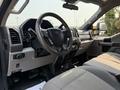 Interior view of a 2020 Ford F-350 SD showing the steering wheel dashboard and gear shifter with cloth seating