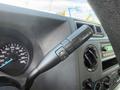 A close-up view of the control lever of a 2023 Ford E-450 featuring buttons for tow haul mode and a dashboard with a speedometer and audio controls