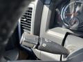 Close-up of the gear shift and dashboard controls in a 2011 RAM 1500 featuring the RPM gauge and turn signal lever