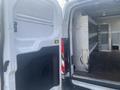 A 2017 Ford Transit van with its back doors open showing the interior storage space and shelves
