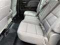 The image shows the rear seating area of a 2016 GMC Sierra 1500 with gray fabric upholstery and seatbelts attached to the seats