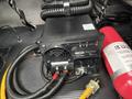 A TripLite PowerVerter inverter connected with wires and plugs on a black surface next to a fire extinguisher
