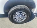A close-up of a wheel and tire from a 2014 Ford F-250 SD with a shiny alloy rim and a rugged tire tread pattern