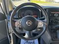 Steering wheel of a 2017 Nissan NV200 with controls and dashboard gauges visible